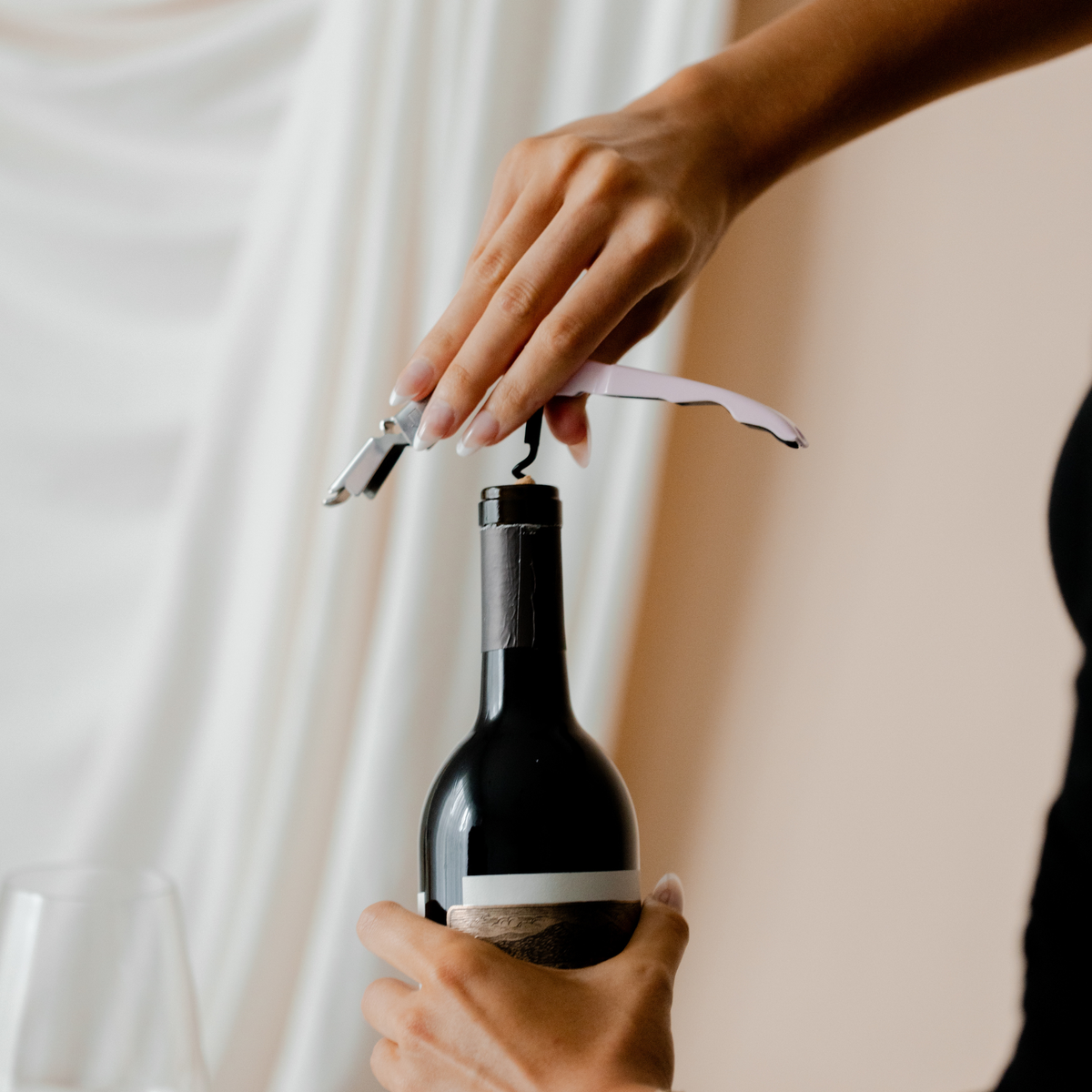 Close-up use of corkscrew from the Savvy Llama wine enthusiast starter kit, the elegant wine opener gift set for women who want to pour with confidence