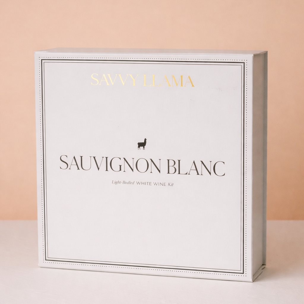 Savvy Llama Sauvignon Blanc wine tasting kit displayed on a soft pink gradient studio background, showing the guided light-bodied white wine tasting tools for women discovering sauvignon blanc at home.